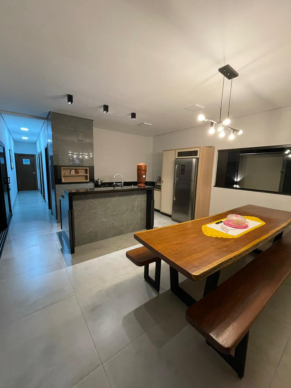 Cozinha gourmet com bancada em mármore e mesa de madeira maciça
